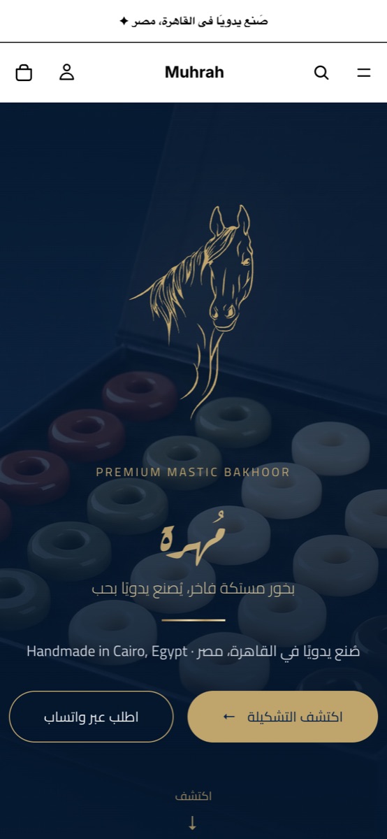 The Muhrah storefront home on a phone: the gold horse emblem over mastic bakhoor, with Explore the collection and Order on WhatsApp.